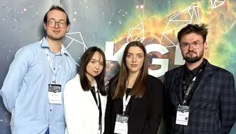 czworo z uczestników na tle banera